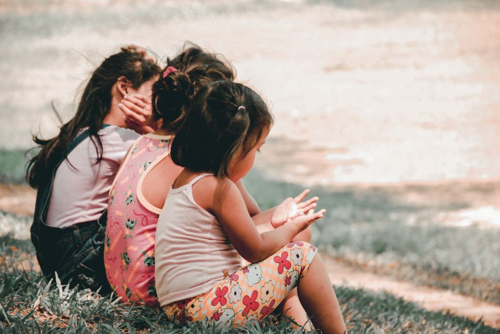 Children sitting on grass. 